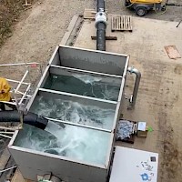 Water being pumped through the water discharge tank and being re-circulated into the old mine workings during pump commissioning